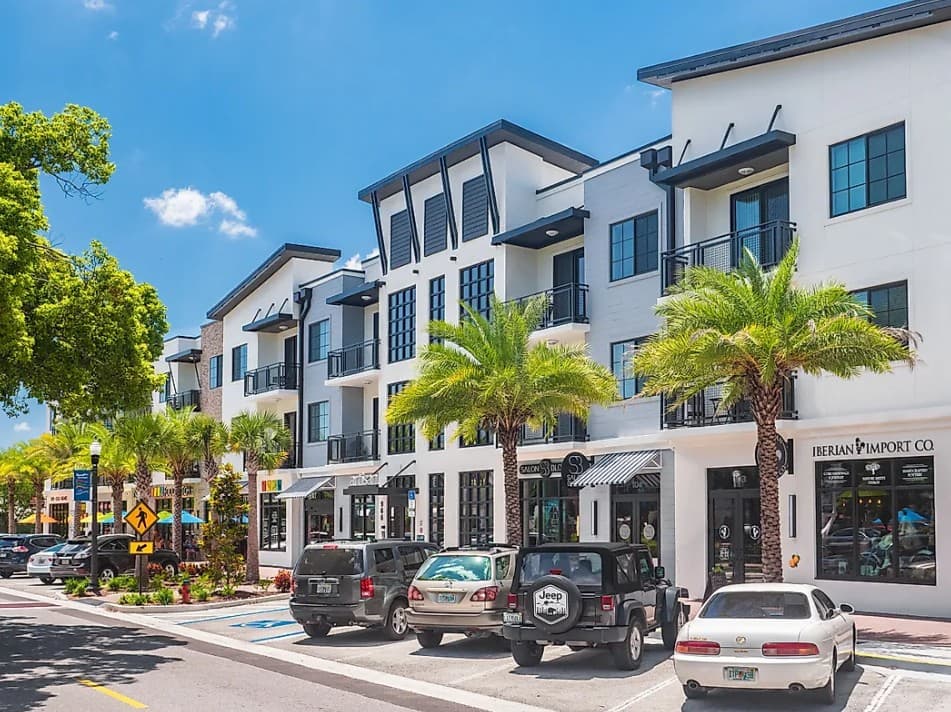 Downtown Dunedin with palm trees, local shops, parked cars, and a sunny walkable Florida main street.