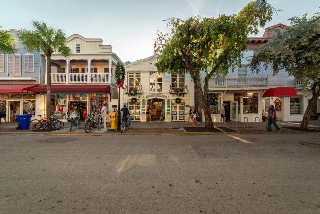 Street view of colorful local shops and pedestrians along Duval Street in Key West, Florida.