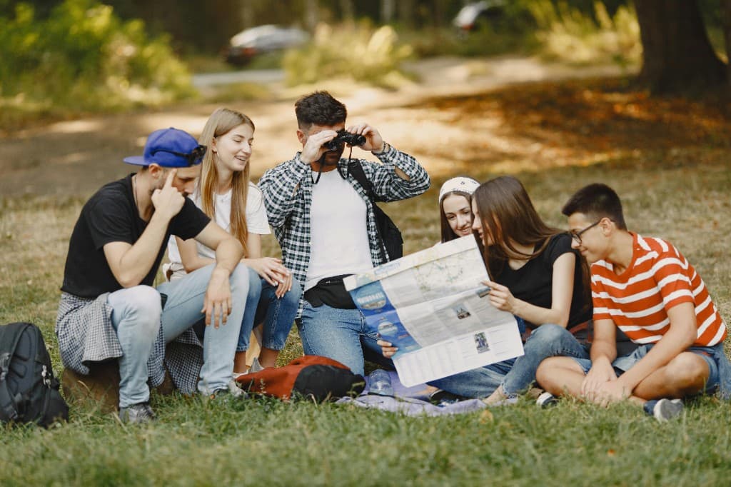 Group of people sitting outside with a map during an outdoor scavenger hunt or community activity.